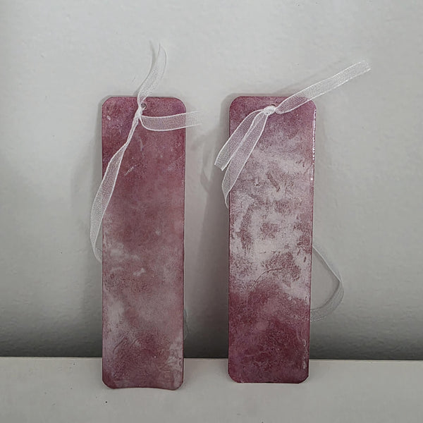 Close-up of terracotta and blush pink bookmarks highlighting the glass-like durability of the UV resin coating and delicate ribbon detail