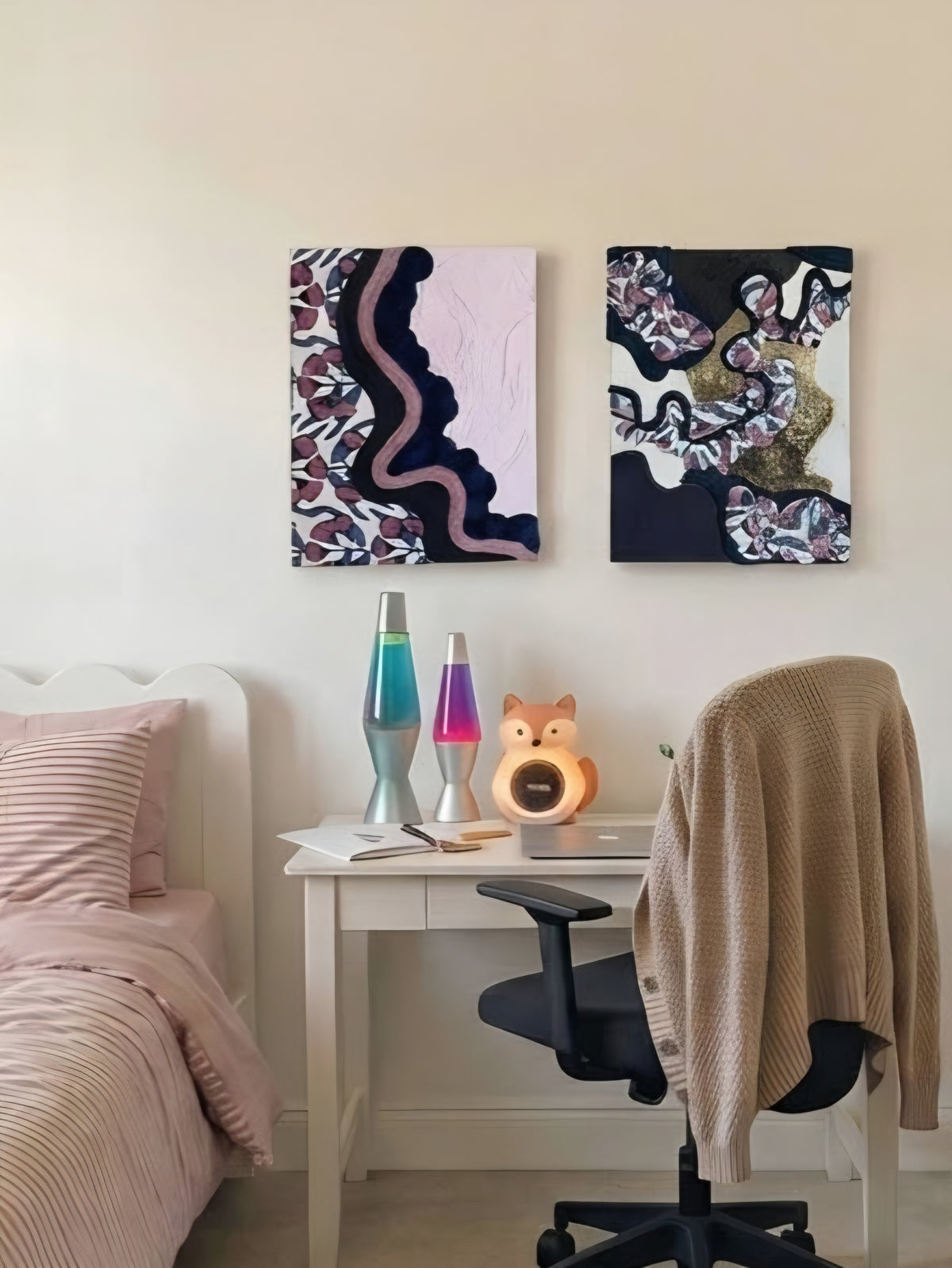 Two framed abstract mixed-media canvas artworks hanging above a white study desk in a child's bedroom.