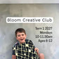 A young boy holding a black and gold textured art piece during a Breathe & Bloom Design creative studio session.