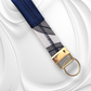 Close-up of a navy blue velvet and monochrome leaf pattern fabric keychain with elegant gold hardware.