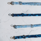 Comparison of gold, silver, and black metal lobster clasps and adjustment slides on various blue fabric straps.
