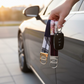 Hand holding two fabric wristlet keychains next to a car door at sunset, demonstrating the wristlets in use.