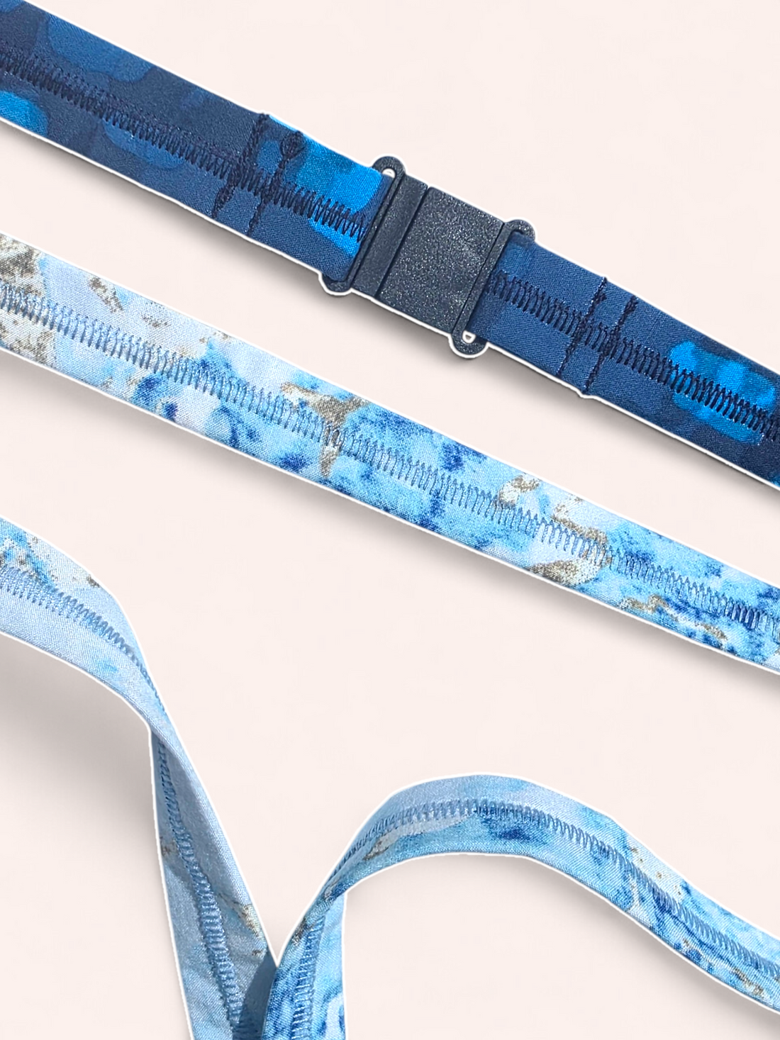 Close-up of a black plastic quick-release safety breakaway clasp on a dark blue patterned lanyard.