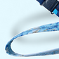 Close-up of a black plastic quick-release safety breakaway clasp on a dark blue patterned lanyard.