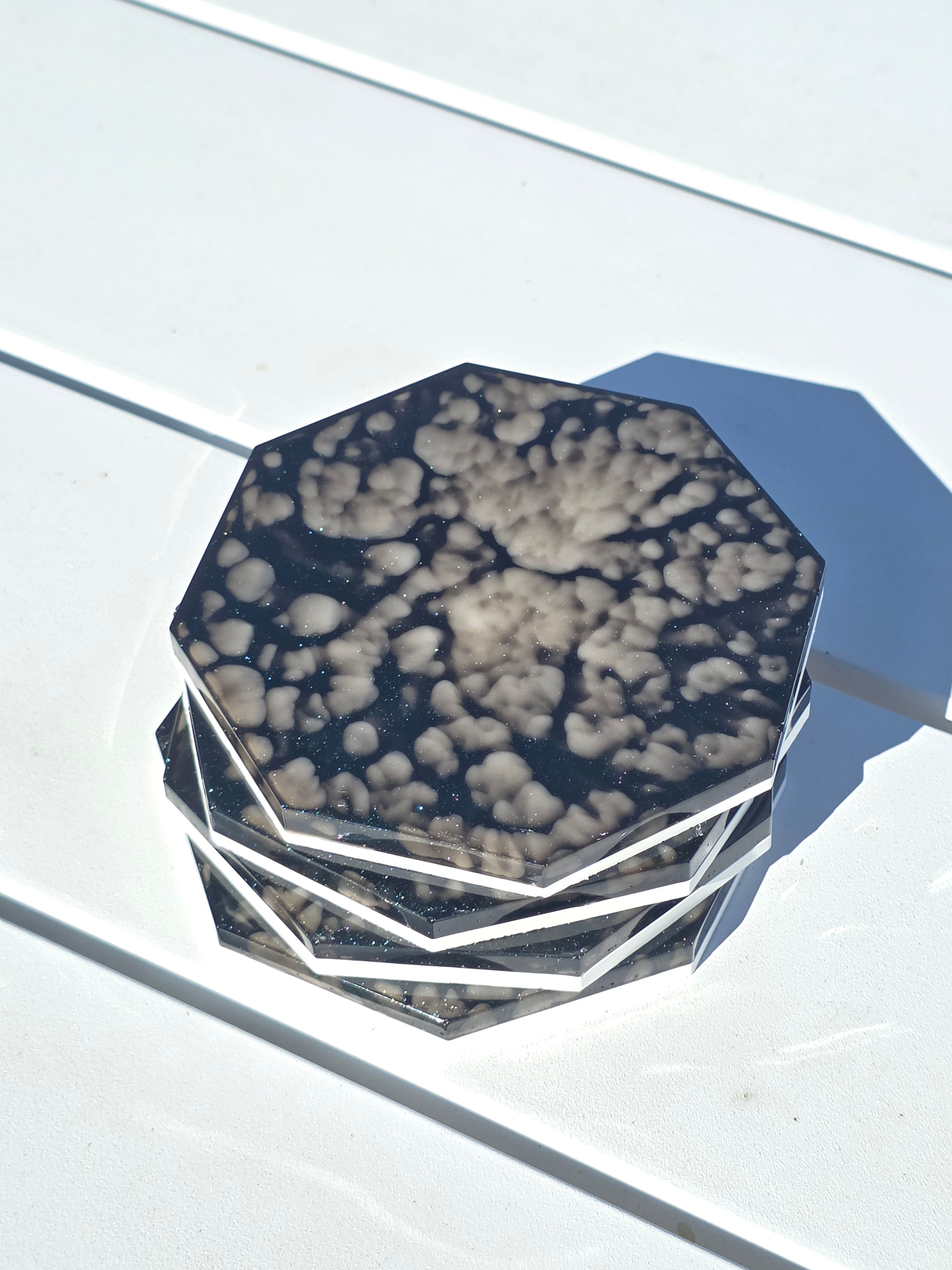 A stack of handmade resin coasters on an outdoor table.